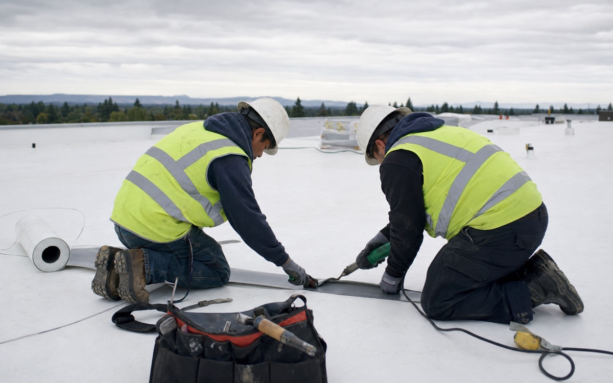 Approved roofing contractors documenting work on a warranted roof